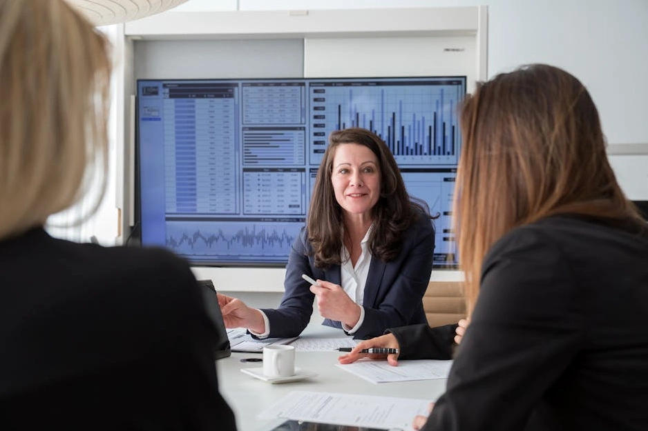 Tým profesionálů diskutuje strategii nad grafy v moderní kanceláři